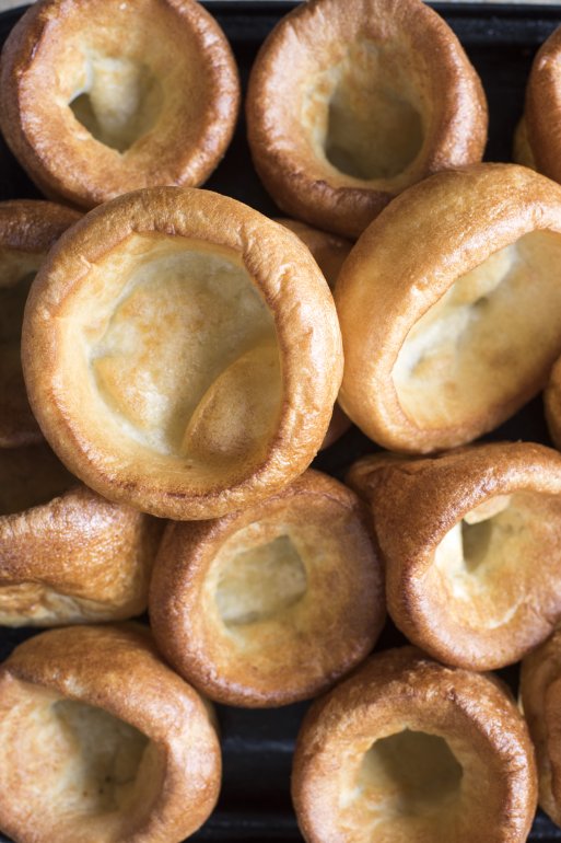 Background of delicious small individual  Yorkshire puddings fresh from the oven viewed full frame close up from overhead