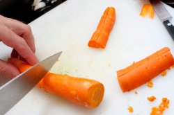 Man cutting fresh whole carrots