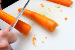 Man scraping carrots with a knife