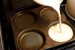 Pouring Yorkshire pudding batter into a pan