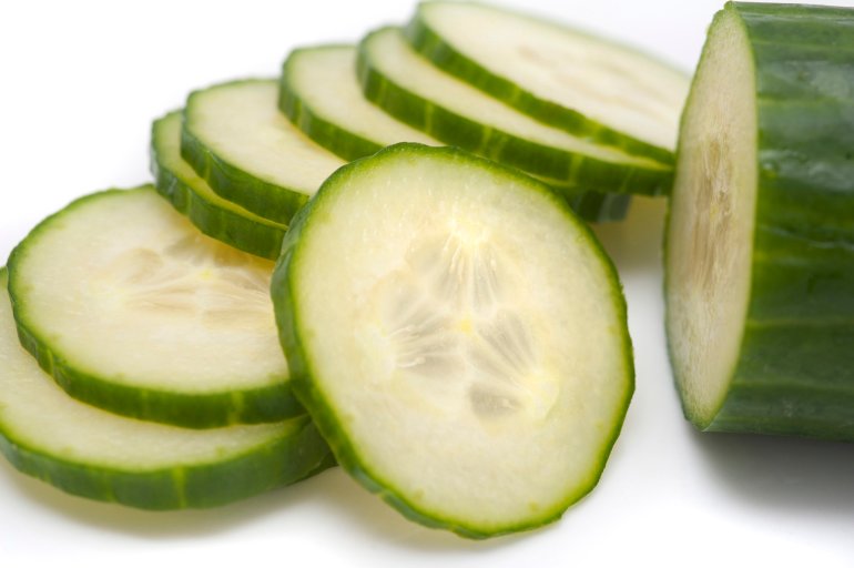 Thinly sliced cucumber being prepared as a salad ingredient showing the pips and flesh detail