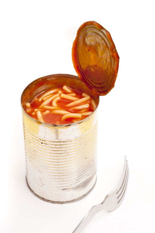 High angle view of an open tin of spaghetti or noodles in tomato sauce with a for alongside on a white background