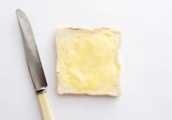Isolated slice of white bread with butter