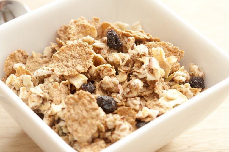 breakfast muesli in a bowl Delicious healthy breakfast muesli in a bowl with assorted cereals, chopped nuts and dried raisins and fruit, close up view