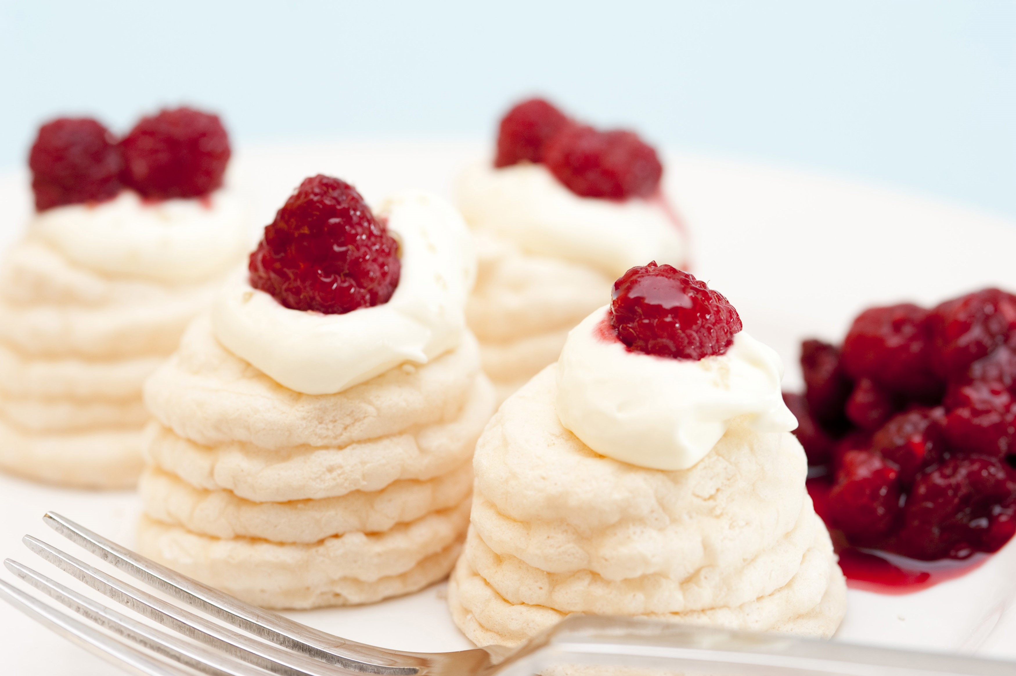 Individual twirled meringues with raspberries Free Stock Image