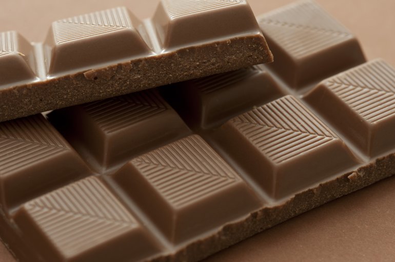 bar of cooking chocolate Bar of milk chocolate with pattern detail on the individual squares of converging lines in a close up view