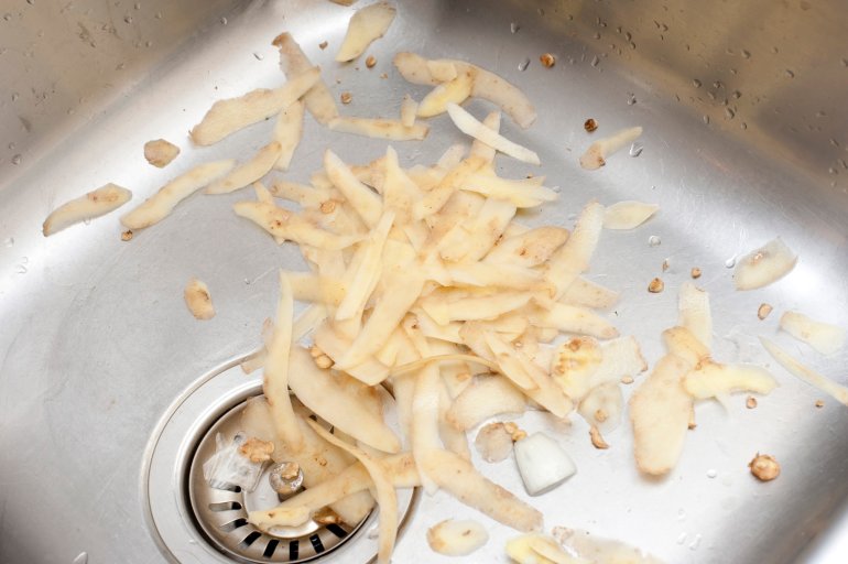 Potato peels in a sink Potato peels lying in a stainless steel kitchen sink waiting to be discarded after preparing the vegetables for cooking