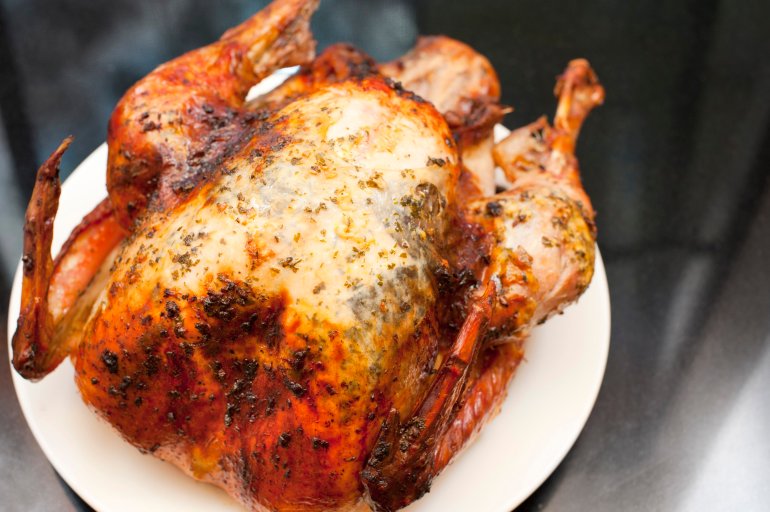 Crisp golden roast turkey High angle view of a whole crisp golden roast turkey served on a plate ready for a tasty festive Thanksgiving or Christmas dinner