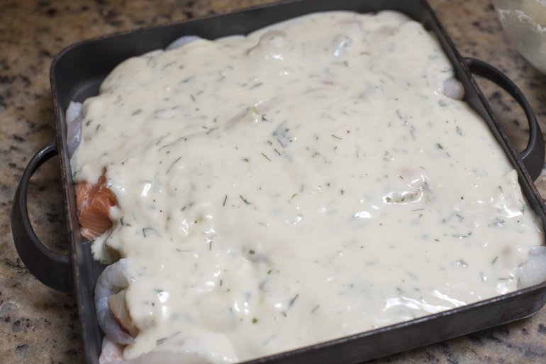 Seafood pie with creamy sauce topping Delicious homemade seafood pie with creamy sauce topping over fish fillets ready in a baking tray