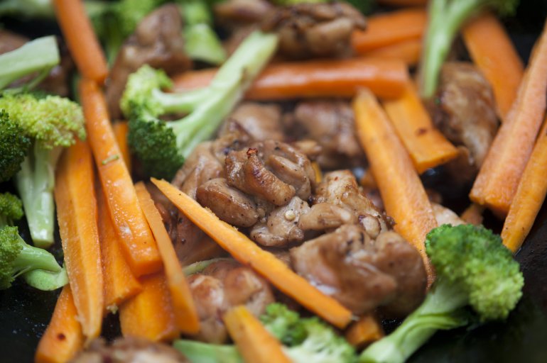 vegetables and chicken stir fry Close up view of delicious cooked vegetables such as carrot sticks and chopped broccoli with small cuts of meat