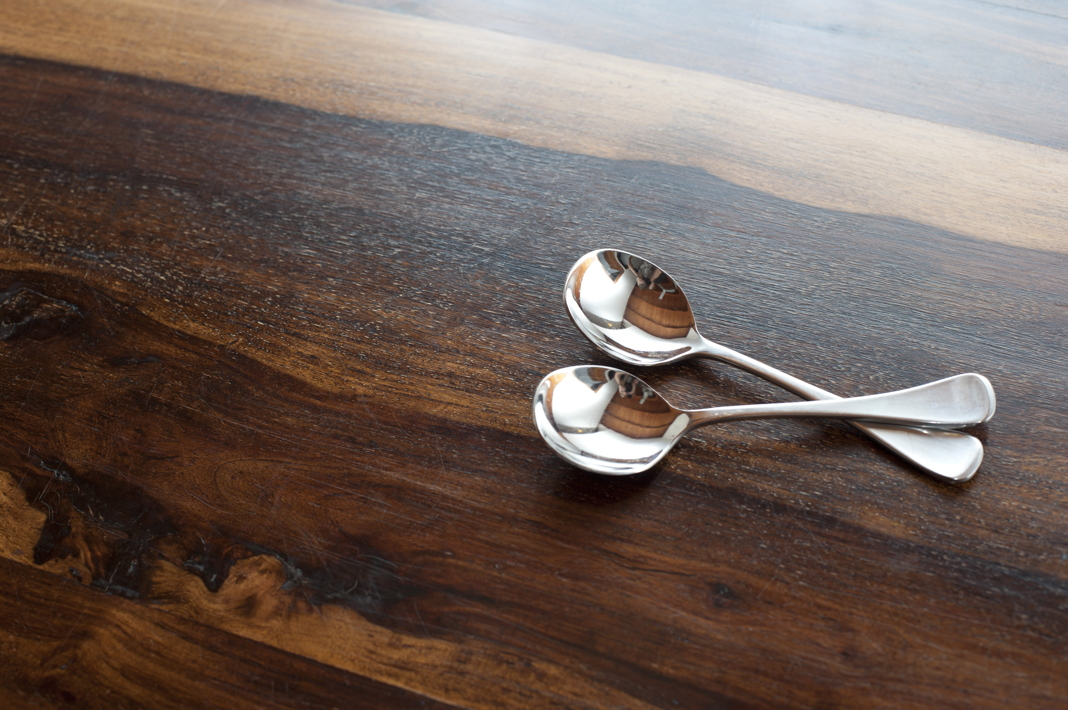 Two silver soup spoons on wood with copy space Free Stock Image