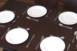 Clean empty generic white plates on a dinner table