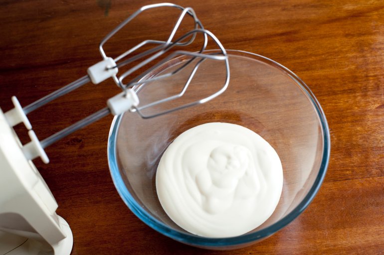Double cream High angle view of a glass mixing bowl and electric mixer with delicious thick double cream in the bottom waiting to be whisked