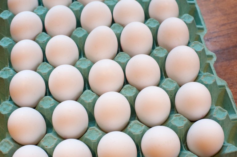 Cardboard tray of delicious farm fresh white hens eggs in a store or farmers market