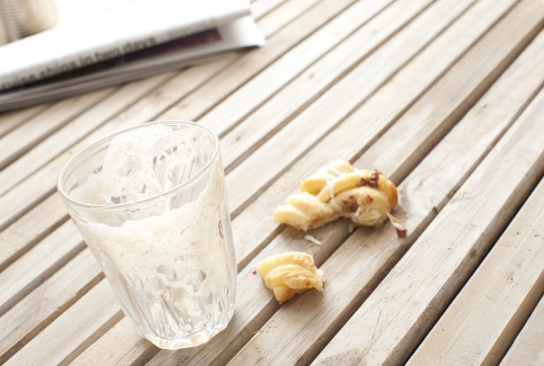 Empty Cafe Latte Glass Cafe table with an mostly eaten danish pastry and an empty coffee glass