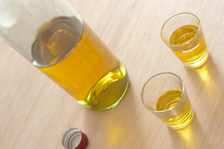 Spirit shots Spirit shots served in shot glasses with an unlabelled bottle of alcohol alongside, possibly Scotch or whiskey viewed at a tilted angle