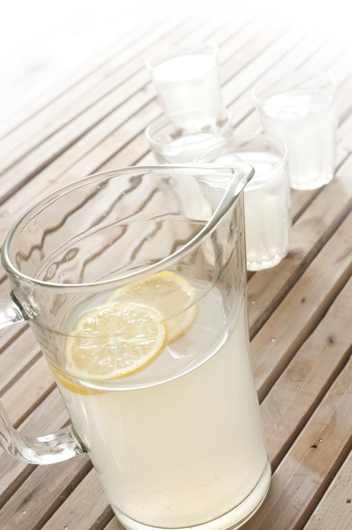 Refreshing fruity summer drinks Refreshing fruity summer drinks with fresh homemade lemonade in a jug with tumblers on a wooden picnic table outdoors
