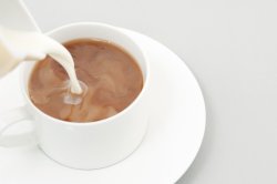 Pouring milk into a cup of coffee