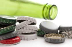 Empty green alcohol bottle with loose caps