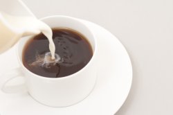 Pouring milk into a cup of coffee