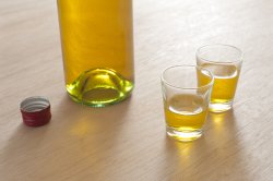 Two full shot glasses with a bottle