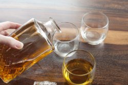 Man pouring tumblers of whiskey