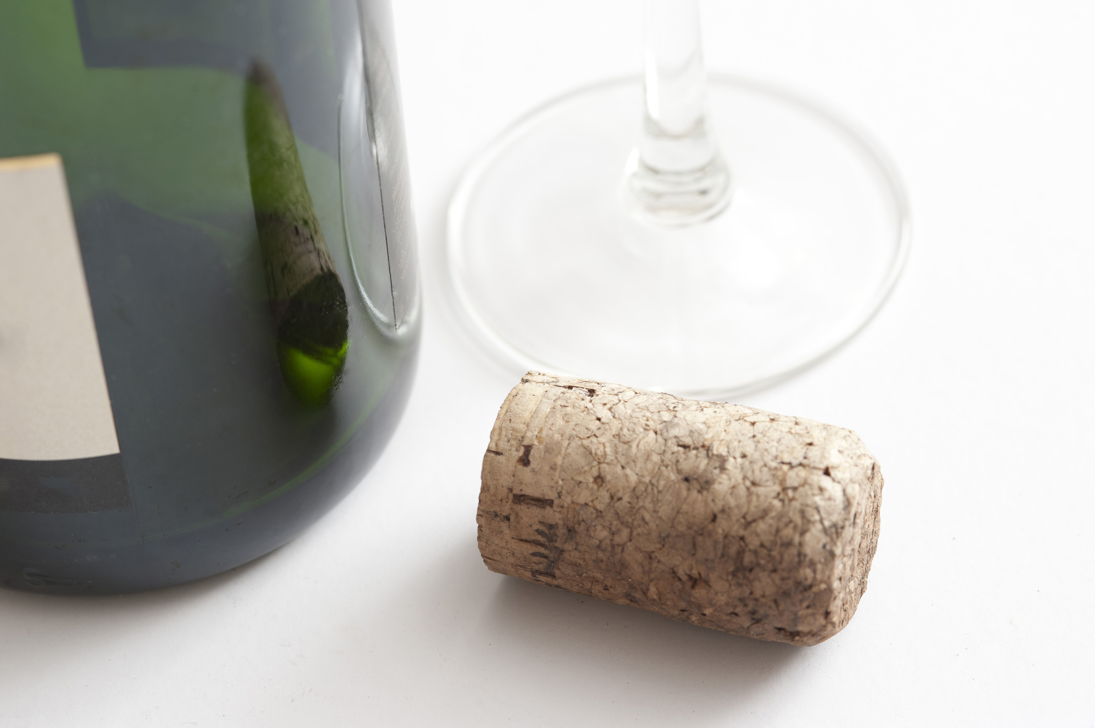 Wine cork alongside a bottle and glass Free Stock Image