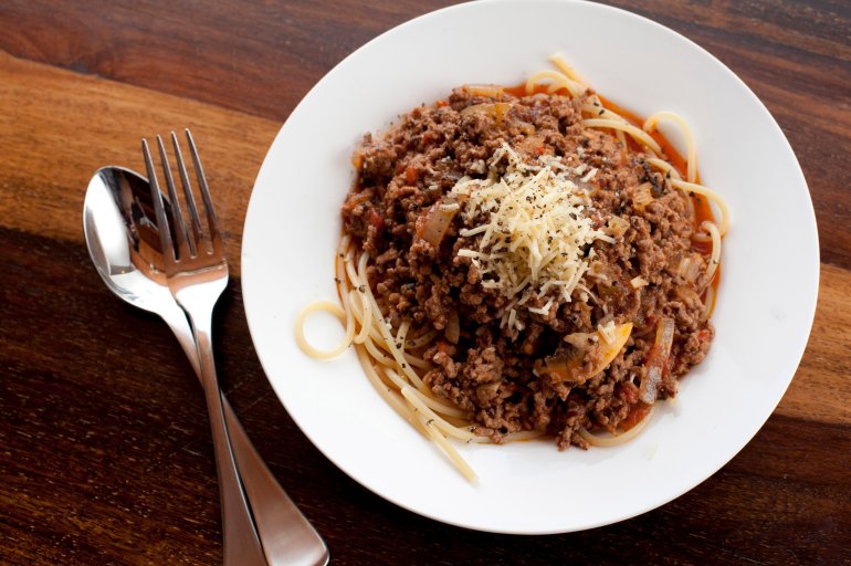 Overhead view of a plate of Italian spaghetti bolognese, or bolognaise, made with beef mince and topped with grated cheese