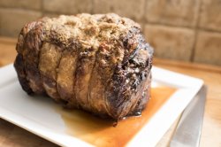 Whole roasted beef joint on a rectangular platter