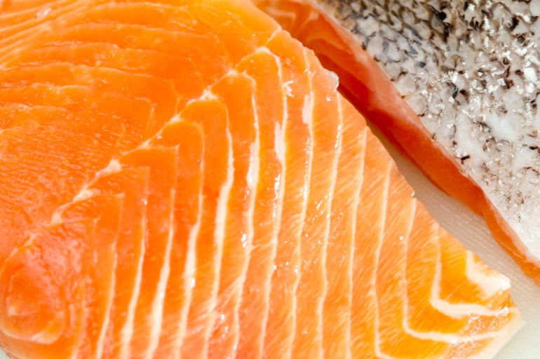 Close up texture of two filleted fresh salmon steaks, one with the flesh uppermost and one with the skin