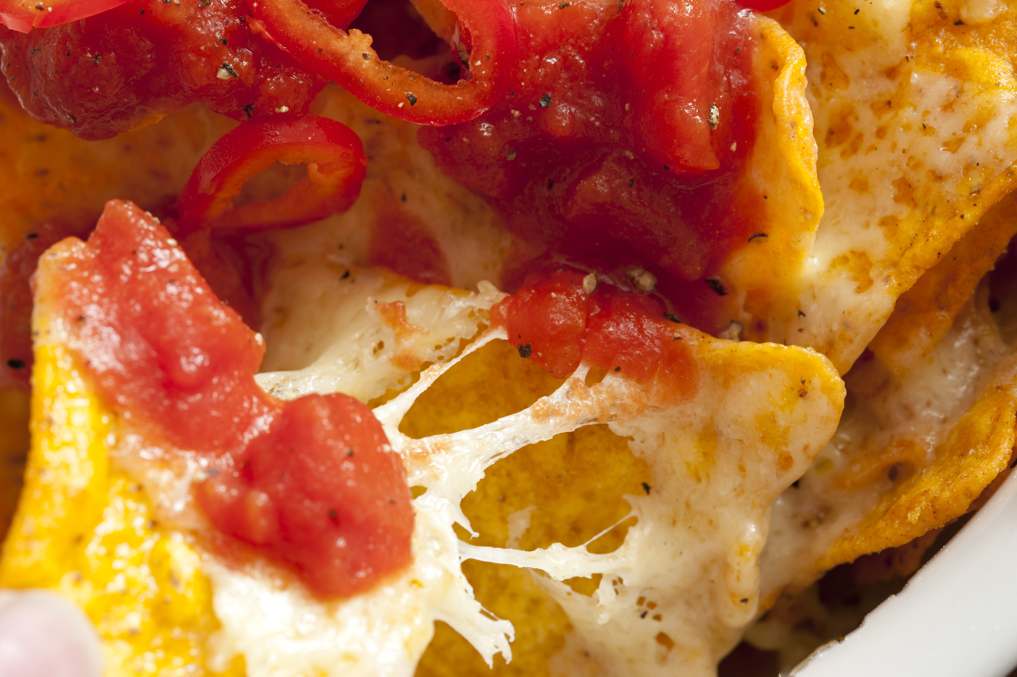 Gooey cheese on nacho chips with salsa Free Stock Image